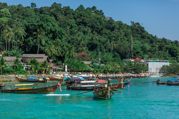 Traditionele Thaise vissersboten die met gekleurde linten worden verpakt. Tegen de achtergrond van een tropisch eiland.