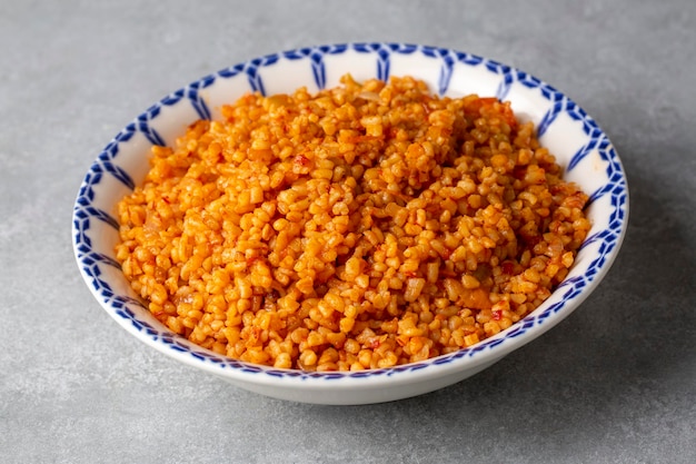 Traditionele Turkse bulgur pilaf met tomatensaus in bord Turkse naam meyhane pilavi of domatesli bulgur pilavi