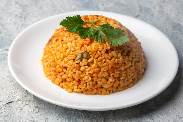 Traditionele Turkse bulgur pilaf met tomatensaus in plaat (Turkse naam; meyhane pilavi)