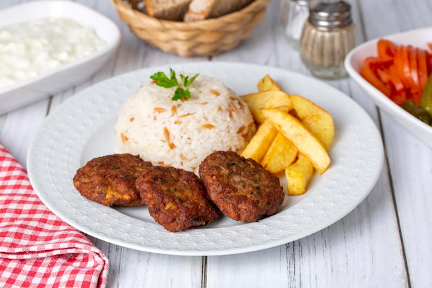 Traditionele Turkse droge gehaktballen of inegol-gehaktballetjes met aardappelen en rijstpilavTurkse naam Kuru kofte