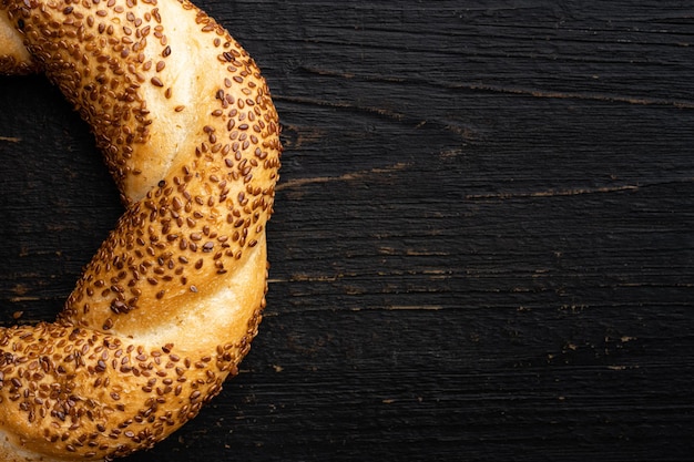 Traditionele turkse simit bagels met sesam op zwarte houten tafel achtergrond bovenaanzicht plat lag met kopieerruimte voor tekst