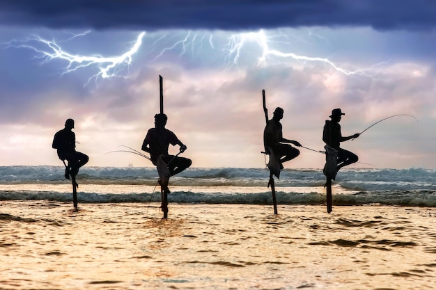 Traditionele vissers op stokken tegen de achtergrond van een stormachtige lucht Donder en bliksem Sri Lanka