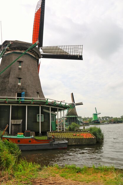 Foto traditionele windmolen bij de rivier tegen de lucht