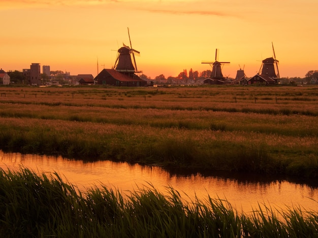 Traditionele windmolen op het veld tegen de hemel tijdens de zonsondergang