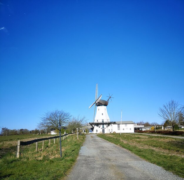 Traditionele windmolen op het veld tegen een heldere blauwe lucht