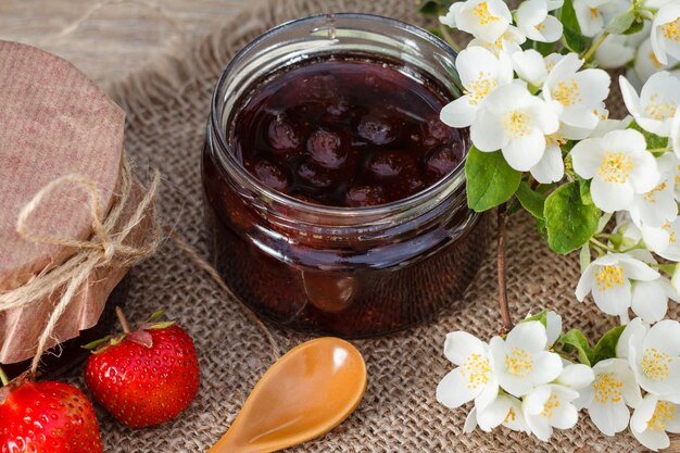 Traditionele zelfgemaakte aardbeienjam in potten, versierd met verse aardbeien en jasmijn Bovenaanzicht Top