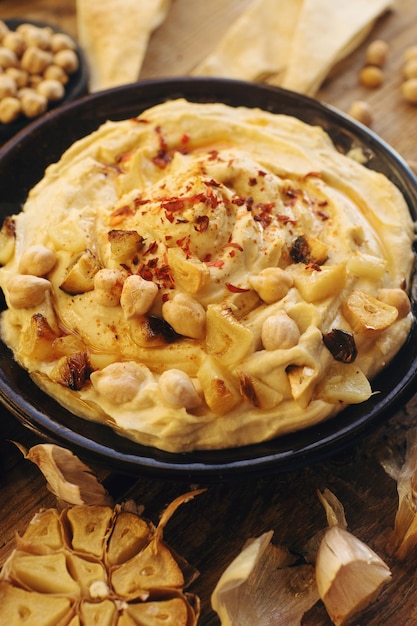 Traditionele zelfgemaakte hummus uit het Midden-Oosten op rustieke houten tafel Oosterse plantaardige snack selectieve focus