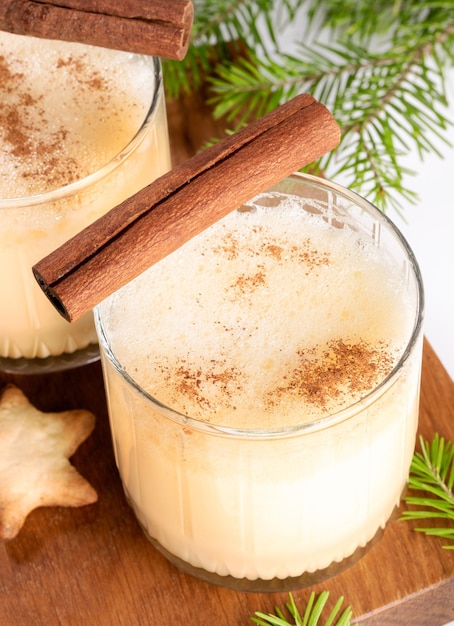 Traditionele zelfgemaakte kerstdrank Advocaat Glazen vakantiedrank op een houten bord op wit