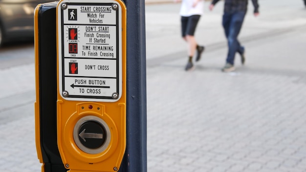 Traffic button on pedestrian crosswalk, push and wait.