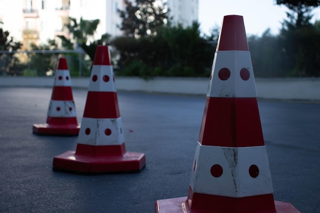 Traffic cones on road with electronic arrow pointing to the right to divert traffic and white car in distance