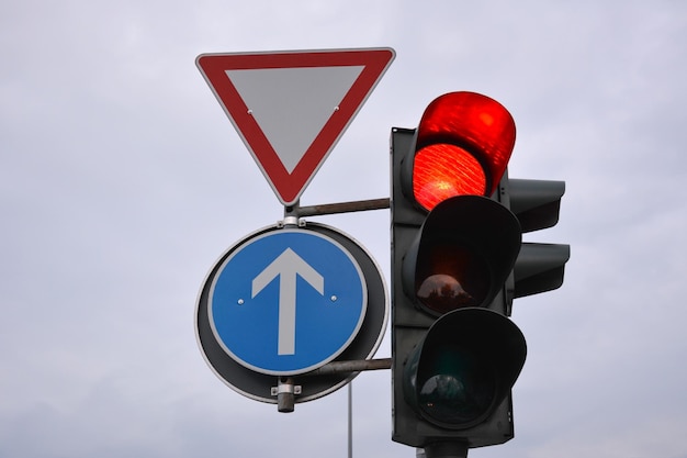 Traffic control signs and traffic light with red prohibitive color on the road pole on sky