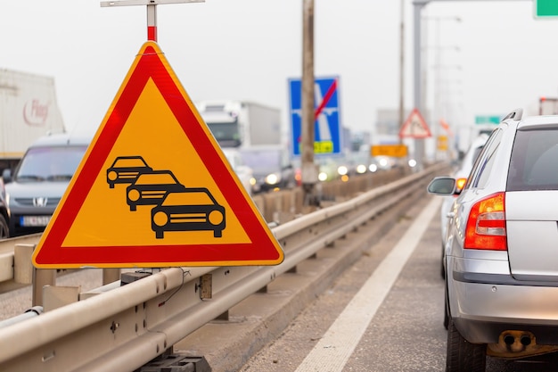 Photo traffic jam sign on a highway with line of cars waiting in row