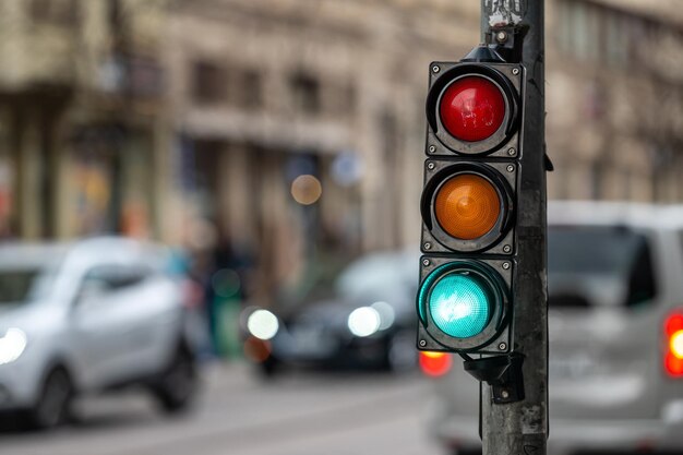 traffic light on the street junction with beautiful bokeh city with cars in the background