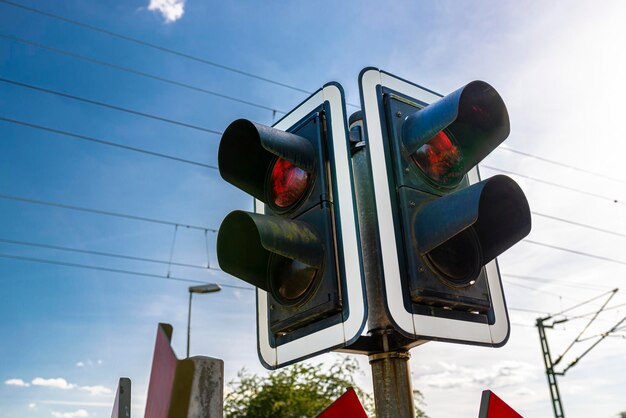 Photo traffic lights before the railway crossing with a red light to warn of approaching trains