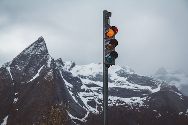 Traffic lights with red turned on the background of snow-capped mountains.