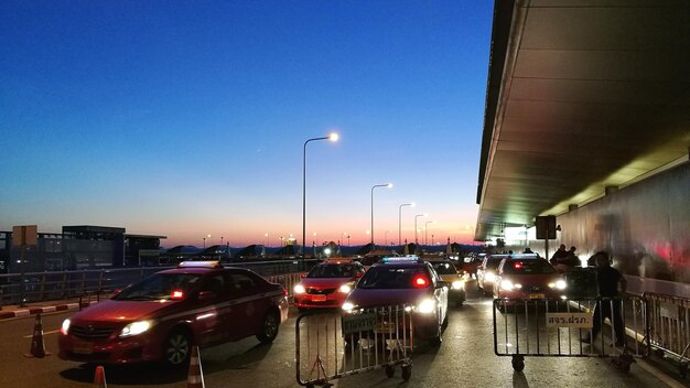 Traffic on road in city against clear blue sky