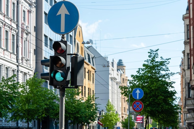 Photo traffic semaphore with green light on the background of defocused urban street closeup