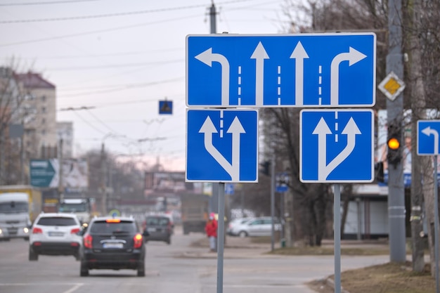 Traffic sign pointing multiple road lanes direction on city street Signboard arrows for urban transport safety guidance