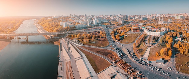 Движение и транспорт в городе Панорамный вид с воздуха на перекрестки и улицы, проходящие через реку по мосту