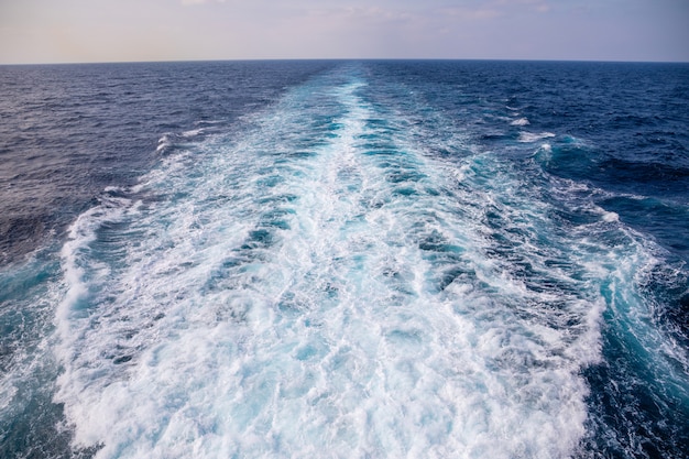 Trail print on water surface behind of cruise ship