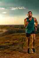 Photo trail run athlete sprinter outdoor athletic man running on sunset wearing in the sportswear fitness