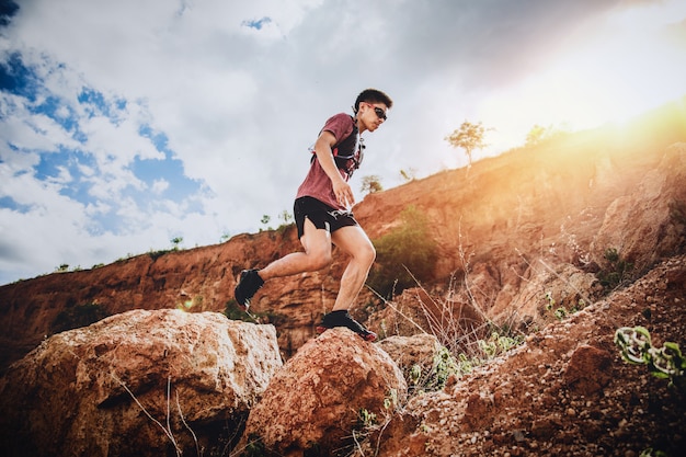 Trail runner springen op de horizon en steen