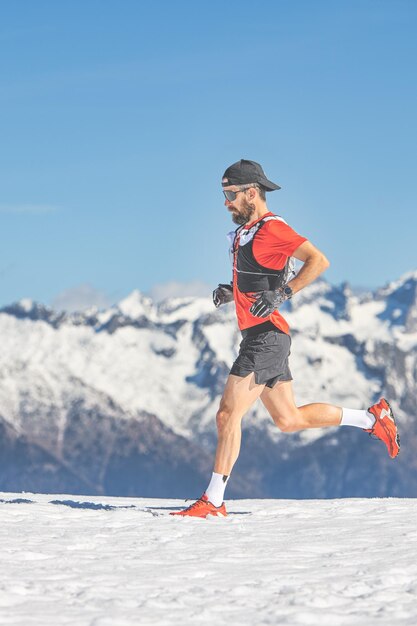 Trail running atleet loopt in de sneeuw