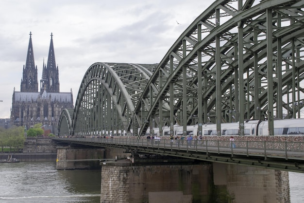 A train on a bridge with a church in the background