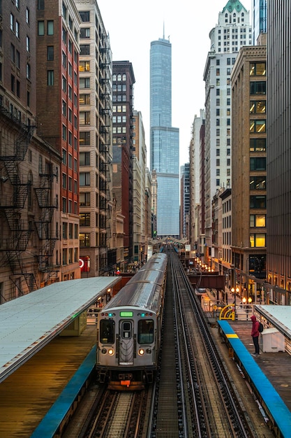 Photo train on elevated tracks within buildings at the loop glass and steel bridge