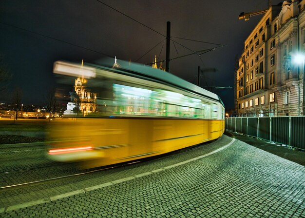 Foto treno su una strada illuminata in città di notte