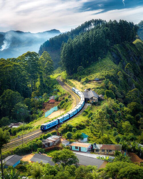 Foto un treno sta scendendo i binari in montagna.