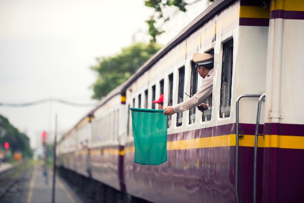 鉄道職員は、鉄道駅から首都に人々を輸送するために、列車に緑色の旗を発します