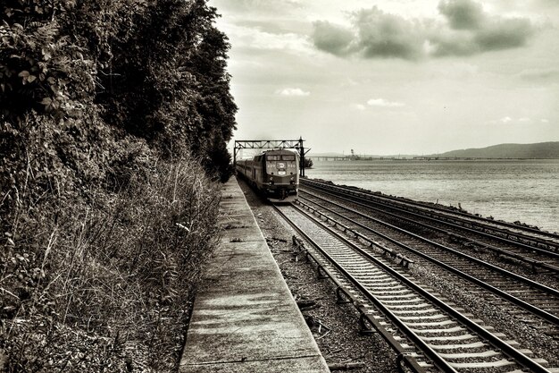 Photo train on railroad track against sky