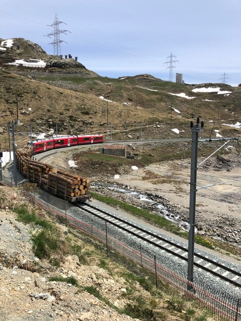 Train on railroad track by mountain against sky