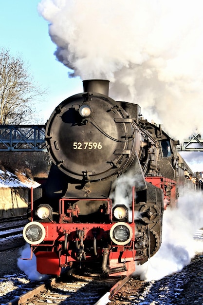 Photo train on railroad tracks against sky during winter