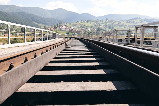 Train rails in country landscape. Railroad tracks at sunset time. Local travel concept.