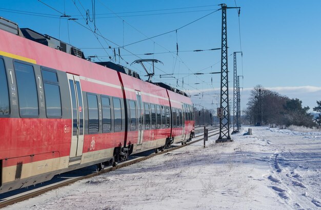 Train on snow covered railroad track against sky