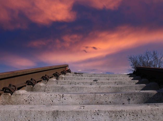 A train track with a pink sky in the background