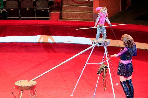 Trained monkey walking on rope with balance beam in circus Amusing monkey performing in Comel circus with tamer
