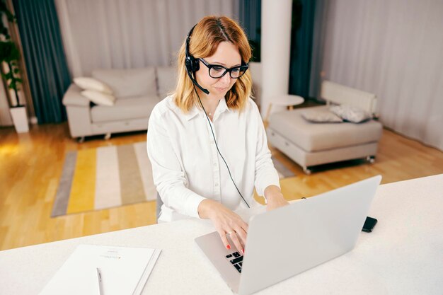 A trainee following the online lectures on her laptop from her cozy home