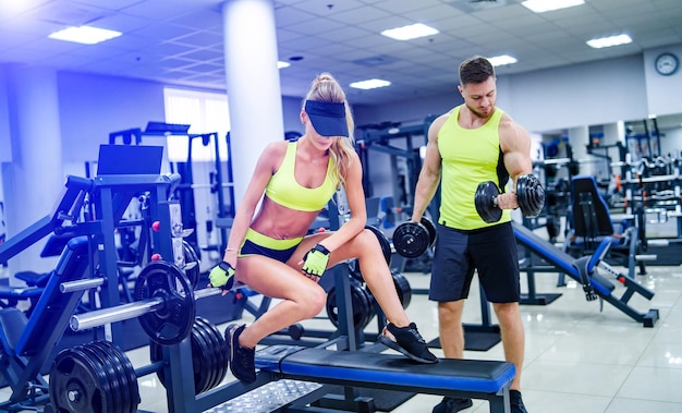 Trainer and client at the gym with sport equipment young and\
fit healthy fitness life concept nice body and long legs healthy\
lifestyle