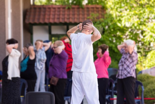 trainer die gemotiveerde actieve gezonde senioren traint om in het park te oefenen