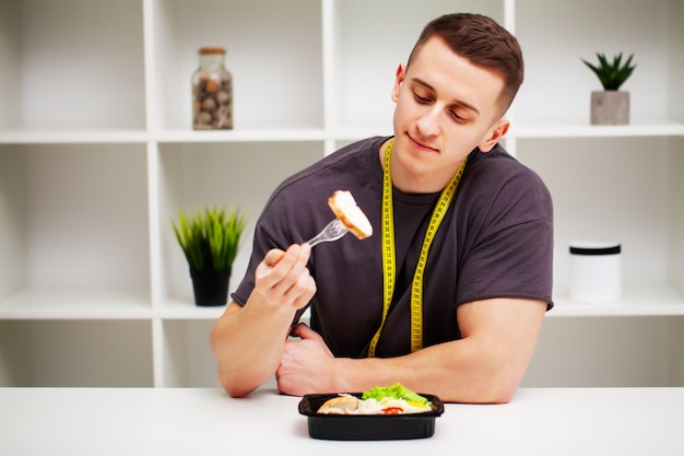 Trainer eet een eiwitrijke maaltijd van vlees en fruit.