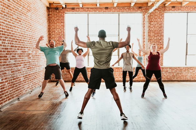 Trainer en zijn studenten strekken zich uit in een studio