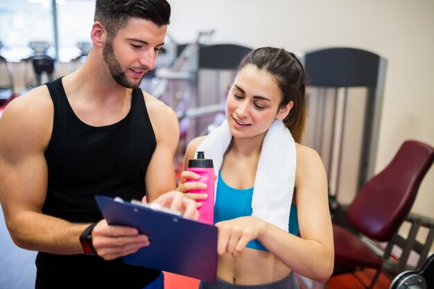 Istruttore che spiega il regime di allenamento alla donna