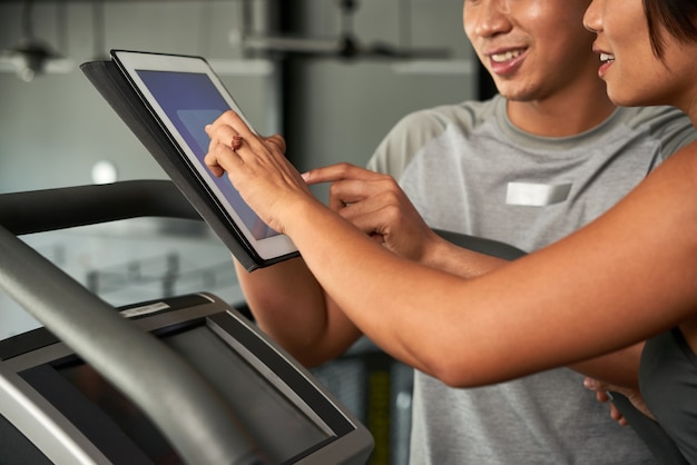 Trainer helping client in gym