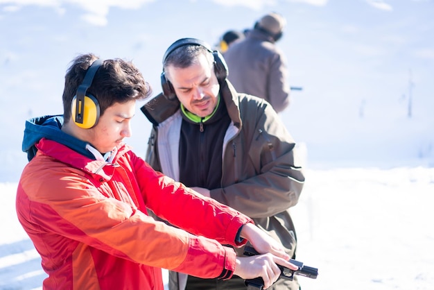 Trainer helping young person to aim with handgun at combat training high quality photo