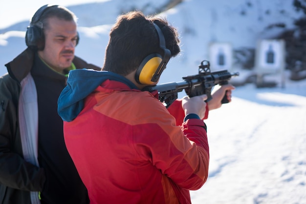 Trainer helping young woman to aim with handgun at combat training. High quality photo