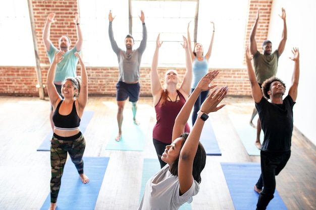 Photo trainer and her students in a urdhva hastasana pose