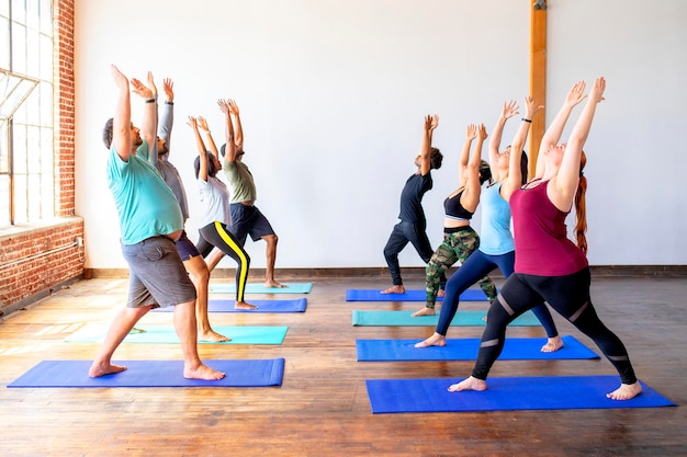 Urdhva Hastasana 포즈의 트레이너와 그녀의 학생들